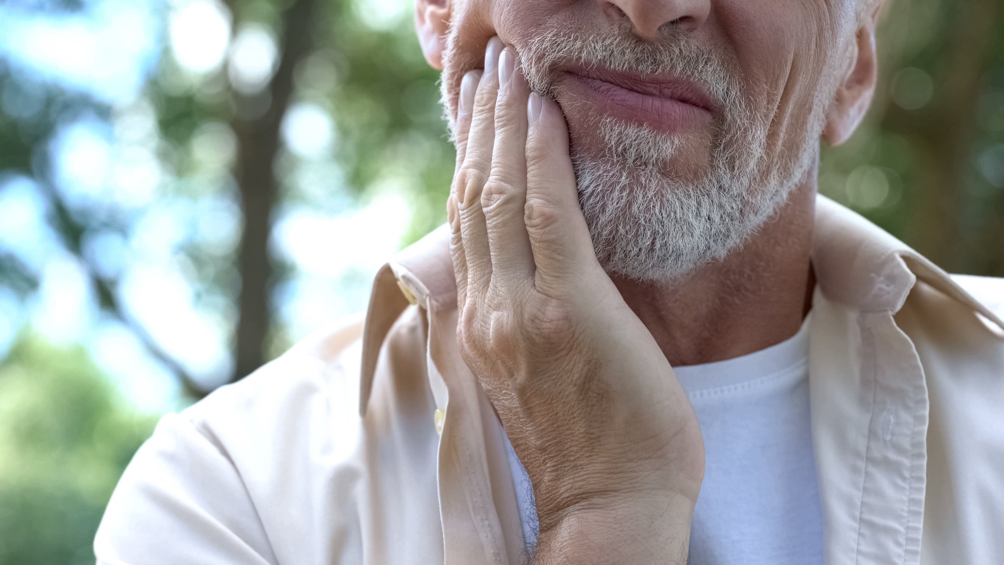 Senior man showing pain from tooth sensitivity